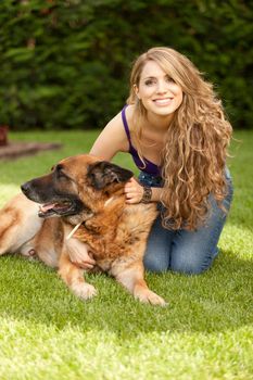 young beautiful woman playing with dog outdoors