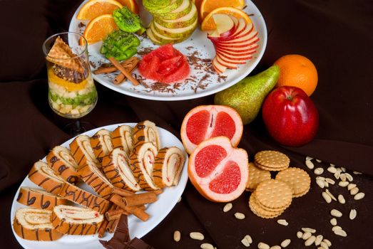 Set of sweet fruit and cake on a dark background