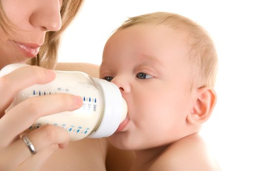 Mother give drink her baby boy by feeding bottle over white