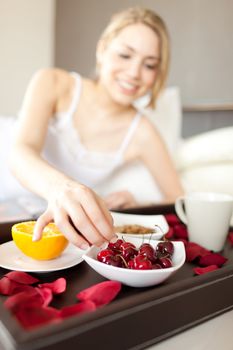 cherries detail in a women breakfast on bed