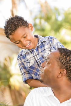 Happy Mixed Race Father and Son Playing in the Park.