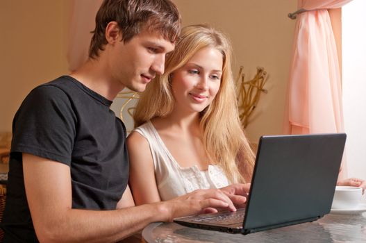 Young couple in the cafe with laptop