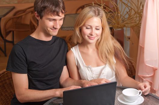 Young couple with laptop in the cafe