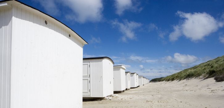 Row of White boathouses on the beach