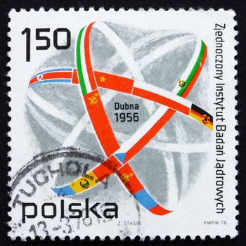 POLAND - CIRCA 1976: a stamp printed in the Poland shows Atom Symbol and Flags, 20th Anniversary of Joint Institute of Nuclear Research, Dubna, circa 1976