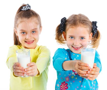 Portrait of happy girls with milk mustache. Focus on the glass. Isolated on white.