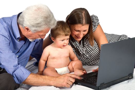 mother and grandfather with baby play with pc