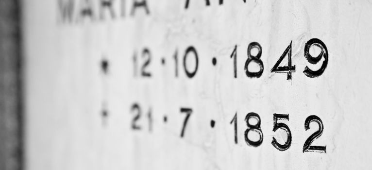 Old tombstone in Italian cemetery with birth and death dates