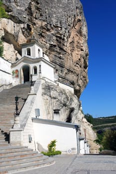 Nice white ortodox temple with long staircase on high mountain. Svyato-Uspensky Monastery in Crimea