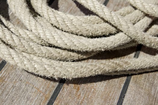 Close-up of thick textile ropes laying on a ship's deck