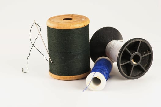 Spool of thread with needle  on white background