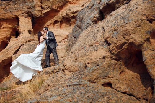 kissing bride and groom in the mountains