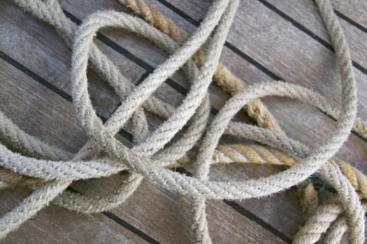 Close-up of thick textile ropes laying on a ship's deck