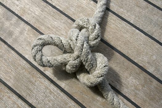 Butterfly knot tied on a thick rope laying on a ship deck