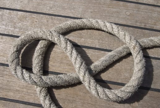 Close-up of thick textile ropes laying on a ship's deck