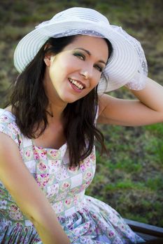 beautiful woman in the summer season with hat in a park