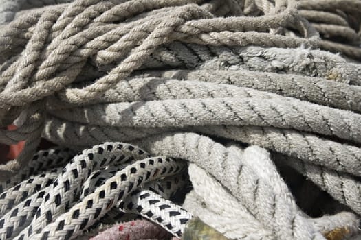 Close-up of thick textile ropes laying on a ship's deck