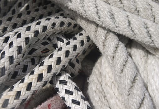 Close-up of thick textile ropes laying on a ship's deck