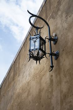 Old metal lantern on wall near palace in Monaco