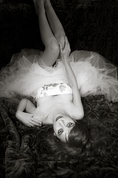 Beautiful redheaded woman lying on a bed of roses in black and white