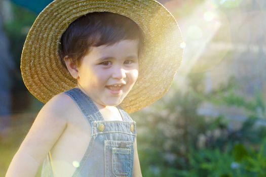 little baby boy gardener smiling playful with sunburst