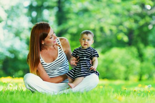 Happy mother and daughter on grass