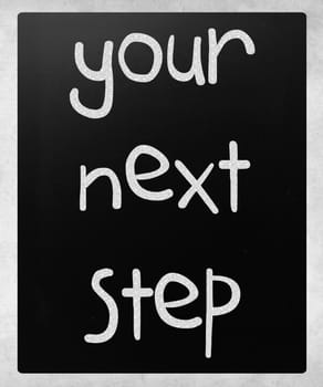 "Your next step" handwritten with white chalk on a blackboard