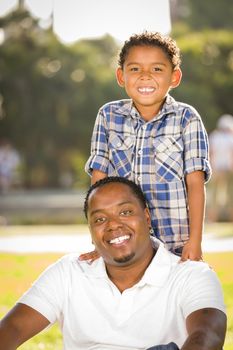 Happy African American Father and Mixed Race Son Playing in the Park.