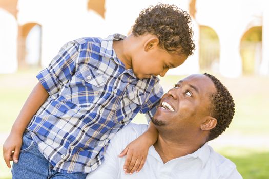 Happy African American Father and Mixed Race Son Playing in the Park.