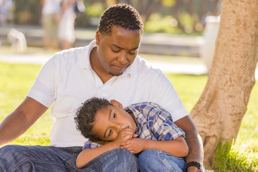 African American Father Worried About His Mixed Race Son as They Sit in the Park.