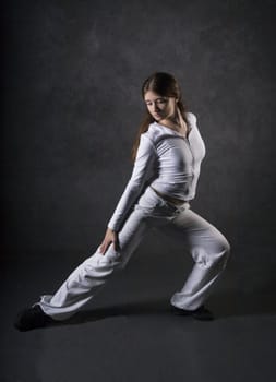 Young woman posing against gray concrete wall