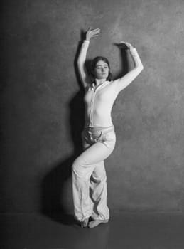 Young woman posing against gray concrete wall