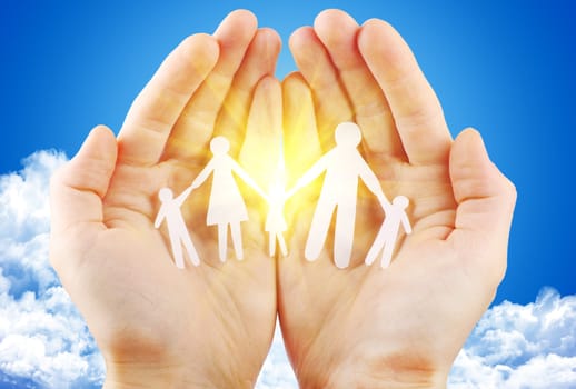 paper family in hand sun and blue sky with copyspace showing freedom or solar power concept