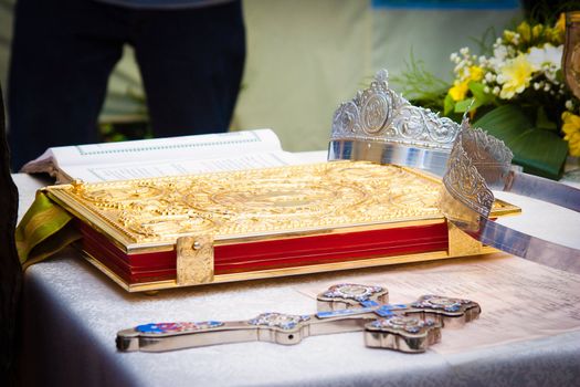 Wedding crowns, cross and bible prepared for ceremony