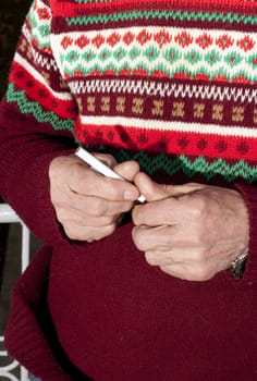 cigarette in his hand against the red sweater