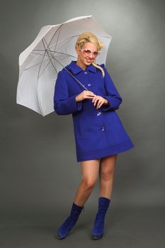 The beautiful blonde in a dark blue coat, wearing spectacles and with a white umbrella