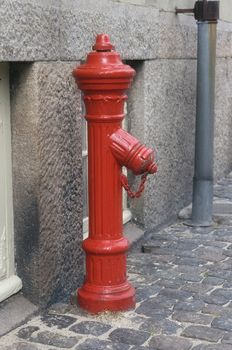 Red fire hydrant on a street in Denmark