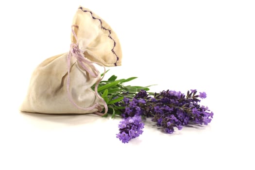 Lavender bag with fresh flowers and green leaves on a light background