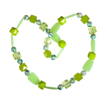 Beads of green glass on a white background laid out in the form of heart