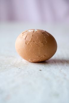 Close up of broken egg on white table. Blured background, shallow DOF