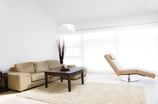 A modern living room with table, sofa and armchair.