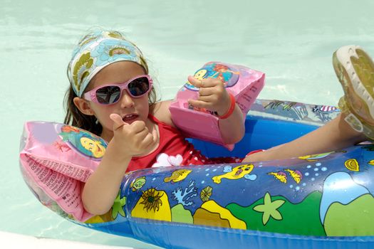 Young child is relaxing in pool.