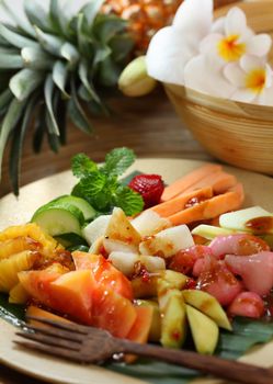 Rujak is a spicy fruit salad made with a (variable) mixture of fruits. The sauce is made by grinding together peanuts, palm sugar, tamarind, terasi (shrimp paste) and chilli