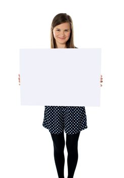 Smiling cute isolated girl displaying blank white poster