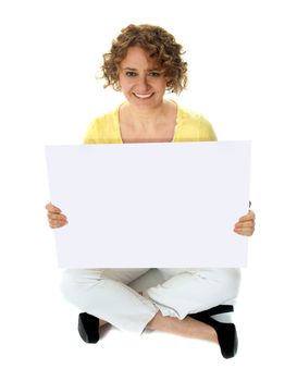 Isolated woman holding blank banner ad sitting on floor. Studio shot