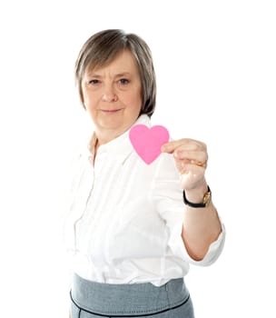 Woman showing heart shaped pink paper to camera