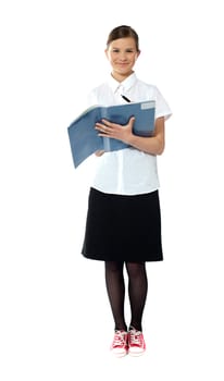 Full length portrait of smiling girl doing homework. All on white background