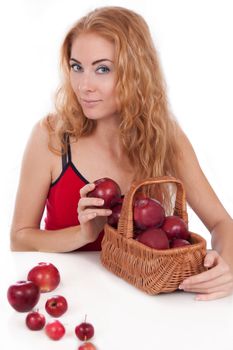 Redheaded woman with basket of apples over white