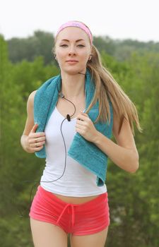 Sporty woman with headphones running outdoor