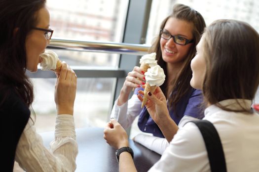 women on foreground licking ice cream 